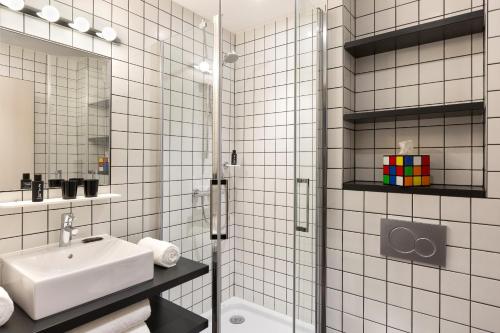 里雾诗RockyPop Chamonix - Les Houches的白色瓷砖浴室设有水槽和淋浴