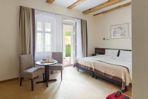 杜什尼基-兹德鲁伊Impresja Art Resort的一间卧室配有一张床、一张桌子和一个窗户。