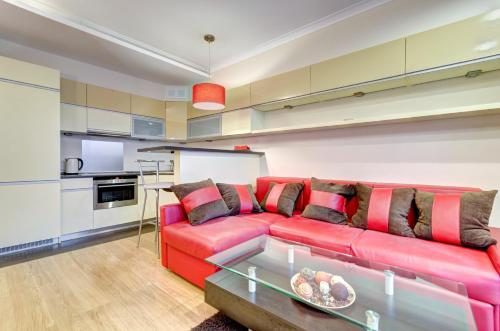 格但斯克Dom & House - Apartamenty Kamienice Nad Motławą的客厅配有红色的沙发和桌子