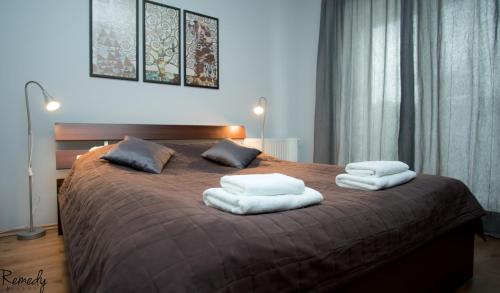 什切青Apartamenty Sedinum - Modern的一间卧室配有一张大床和两条毛巾