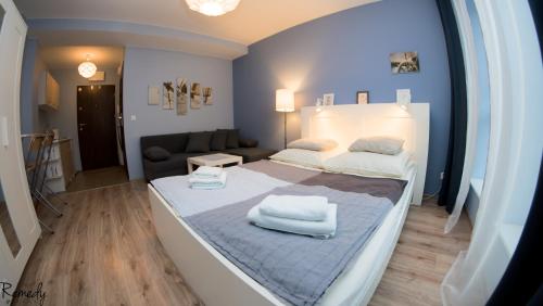 什切青Apartamenty Sedinum - Bryza的一间卧室配有一张带两条白色毛巾的床