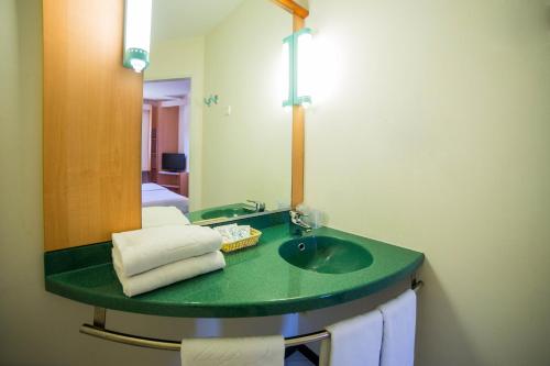 瓜达拉哈拉Hotel Iris Guadalajara的一间带绿色水槽和镜子的浴室