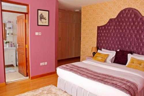 内罗毕萨尔米亚广场旅馆的一间卧室配有一张大床和大床头板