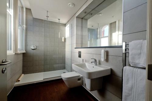 格里姆斯比The Yarborough Hotel Wetherspoon的一间带水槽、卫生间和镜子的浴室