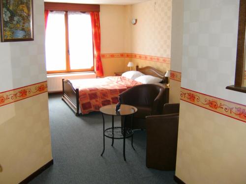 雅莱勒佩蒂特诺曼德酒店的酒店客房配有床、沙发和桌子。