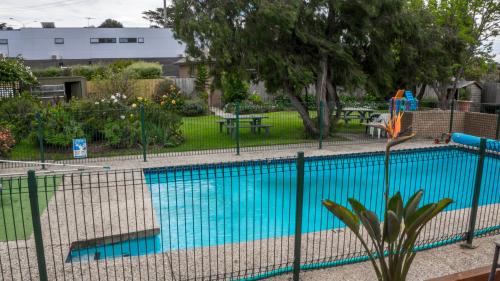 吉朗帕克伍德公寓汽车旅馆的游泳池周围的围栏和游乐场