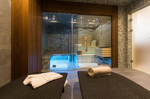 茨里克韦尼察Hotel Crikvenica的一间设有玻璃门的房间,在长凳上配有毛巾