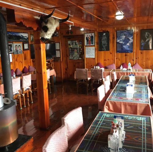 NamcheHotel Khangri的一间设有两张桌子的用餐室和墙上的牛头