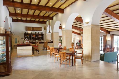 洛斯巴里奥斯瓜达科特公园酒店的一间带桌椅的餐厅和一间酒吧