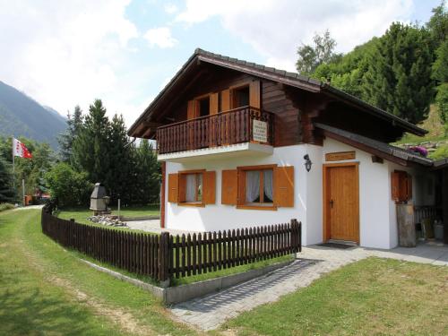 南达Chalet in Saclentse Basse Nendaz near Ski Area的带阳台和围栏的小房子