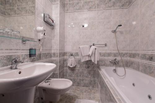 比尔森维多利亚酒店的浴室配有盥洗盆、卫生间和浴缸。