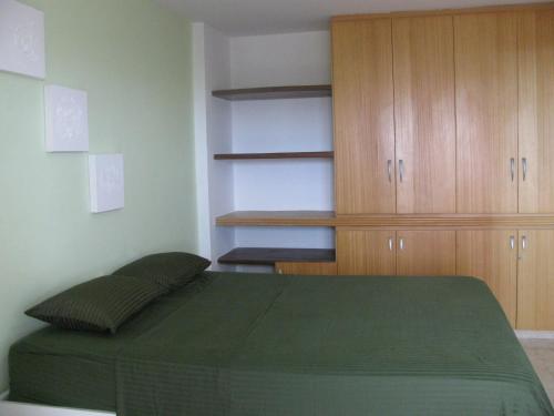 卡贝德卢Victory Flat Intermares的一间卧室配有一张绿色的床和木制橱柜。