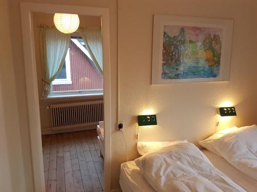 VestnanhavnBudget Guesthouse Borgustova的一间卧室设有两张床和窗户。
