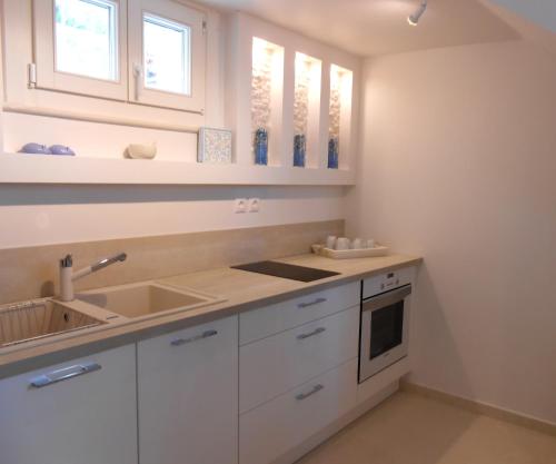 伊兹拉HydraVista (Pearl)的厨房配有白色橱柜和水槽