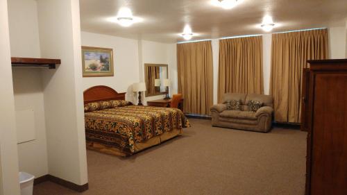 Manvel乡村丽晶酒店及套房的配有一张床和一把椅子的酒店客房
