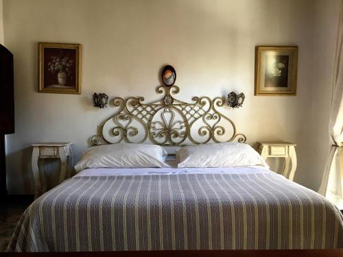圣安东尼奥德阿雷科Hotel Draghi的卧室内的一张带金属床头板的大床