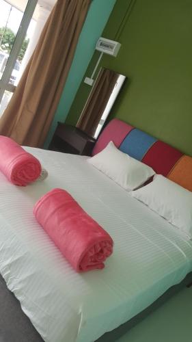 瓜拉勿述伊泽2号经济旅馆的一间卧室配有一张带红色枕头的床