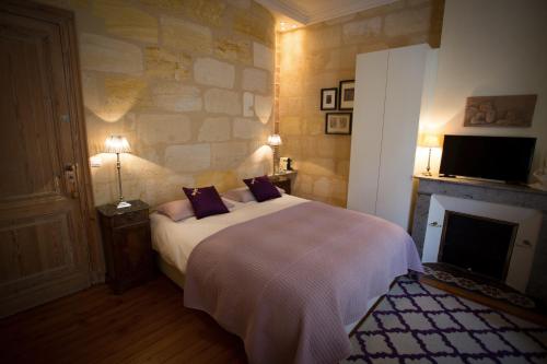 波尔多MAISON D'HÔTES "Bordeaux Wine Lodge"的一间卧室设有一张大床和一个壁炉