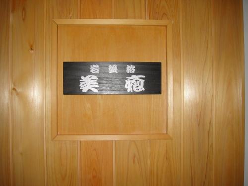 汤泽町音羽屋旅馆的木门上的标志,上面写着