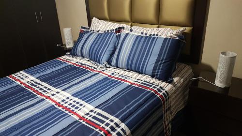利马Lima Flats 3的一张带蓝色和白色条纹床单和枕头的床