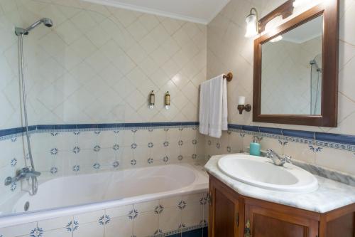 蓬塔德尔加达Azor Beach Lodge的带浴缸、水槽和镜子的浴室