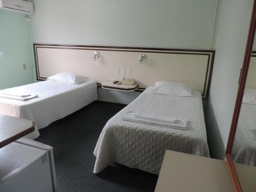 南河镇Hotel Demarchi的酒店客房,设有两张床和镜子