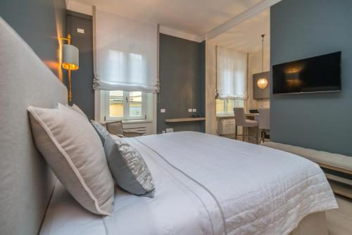 米兰布雷拉奢华套房公寓的卧室配有带枕头的大型白色床