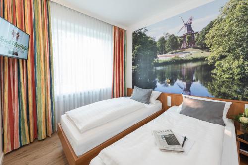不莱梅威斯特伐利亚酒店 的一张带风车画的房间的两张床