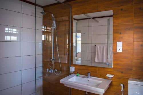 努沃勒埃利耶玛丽山宾馆的一间带水槽、淋浴和镜子的浴室