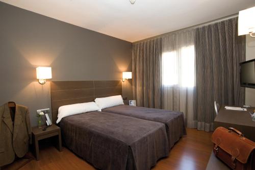 阿尔卡拉德荷那利斯西斯内罗斯酒店的酒店客房,配有床和电视