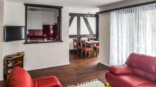 萨斯阿尔马格尔尚纳公寓式酒店的客厅配有红色的沙发和桌子