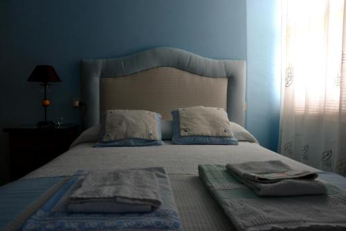 LadridoPension Bajamar的蓝色卧室,配有带毛巾的床