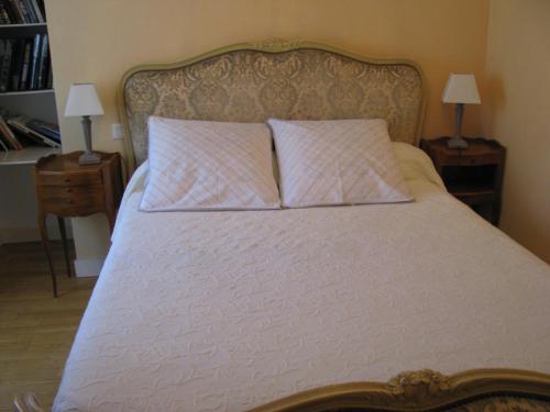 Val CouesnonGîte l'Hermine的一张带两个枕头的床和两张桌子