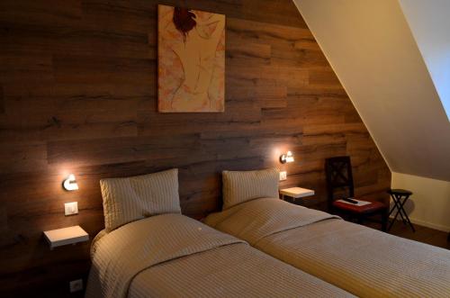 罗珀南Hôtel Restaurant La Couronne的木墙客房的两张床