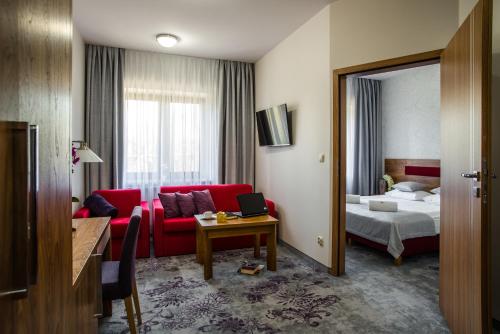 比亚瓦波德拉斯卡波洛尼亚酒店的酒店客房配有红色的沙发和床。