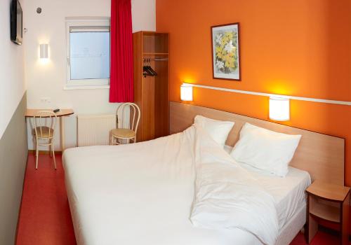 布雷达布雷达普瑞米尔经典酒店的一间卧室配有一张白色的床和橙色的墙壁