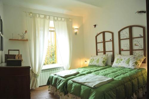 普拉罗莫园丁度假屋的一间卧室设有一张带窗户的绿色床