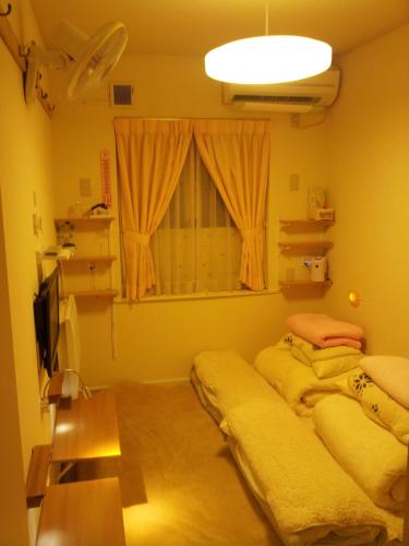 八王子市東京民宿 八王子之家的带窗户的客房内的两张床