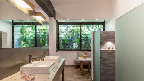 塔马林多卡拉鲁纳精品别墅酒店的一间带两个盥洗盆和大镜子的浴室