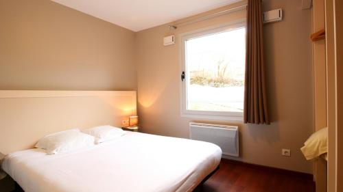 皮什朗德奥克斯巴肯杜桑西公寓式酒店的卧室配有白色的床和窗户。