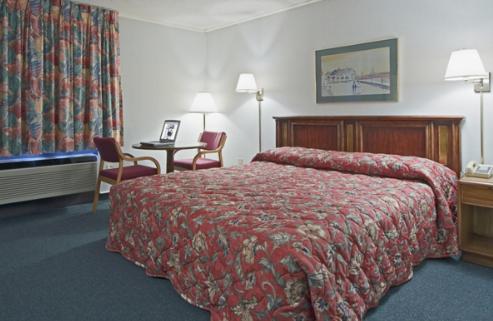 BishopvilleAmericas Best Value Inn - Bishopville的酒店客房带一张床、一张桌子和椅子
