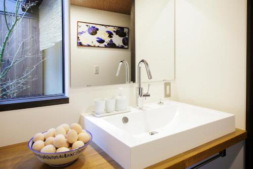 京都町屋红叶度假屋的浴室设有白色水槽和一碗鸡蛋
