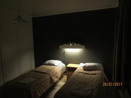凯米Huoneistohotelli Jokikeskus的一间黑暗的房间,配有两张床和一盏灯