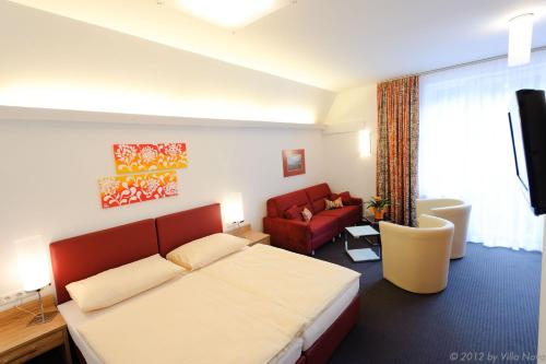 伊布斯河畔魏德霍芬诺拉别墅 - 加尼酒店的酒店客房,配有一张床和一张红色的沙发