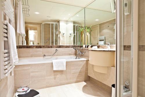 布鲁塞尔勒查特莱兰酒店的带浴缸和盥洗盆的浴室