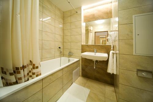 布拉格克里斯塔尔酒店的浴室配有盥洗盆、浴缸和盥洗盆