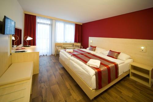 布拉格克里斯塔尔酒店的一间卧室设有一张红色墙壁的大床