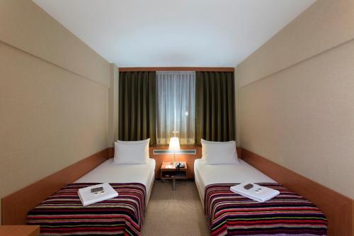 伯萨肯特酒店 的酒店客房设有两张床和窗户。