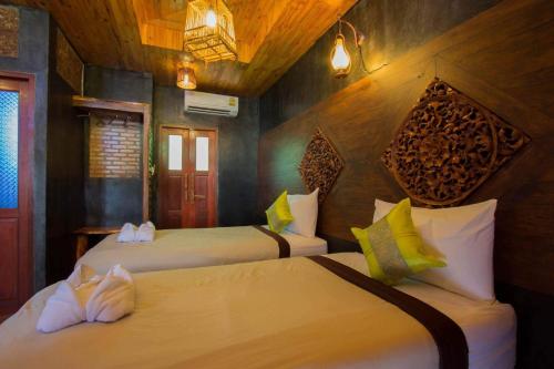 Haad Pleayleam海岩度假酒店的一间卧室,配有两张床