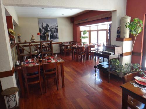 拉巴斯Rendezvous Hostal的用餐室配有木桌和椅子